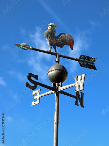 vintage weathercock in iron on blue sky background