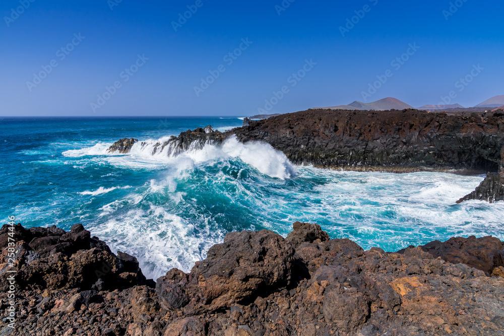 Obraz premium Spain, Lanzarote, Giant breaking wave flooding into los hervideros cove