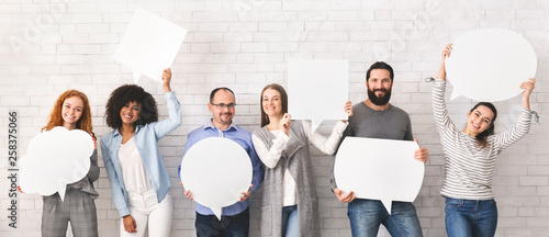 Group of millennial people holding empty speech bubbles photo