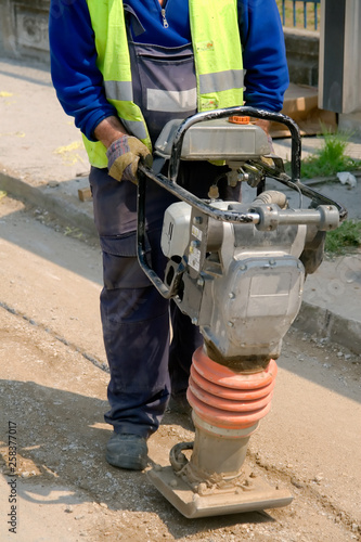 Worker in reflective vest repairing the street