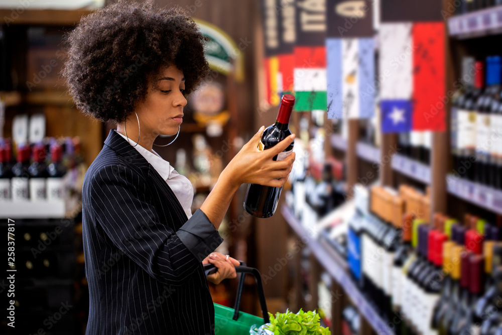 African business Woman holding bottles of wine in supermarket African business Woman holding bottles of wine in supermarket