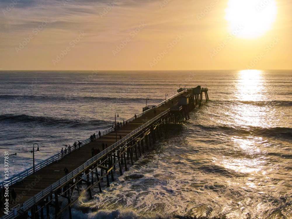 Aerial view of San Clemente Pier during beautiful sunset time. San Clemente city in Orange County, California, USA. Travel destination in the South West coast. Sunset color reflection over the water.