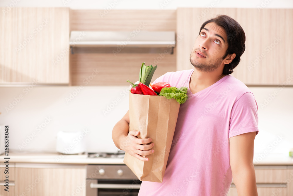Young handsome man with vegetables in the kitchen Young handsome man with vegetables in the kitchen