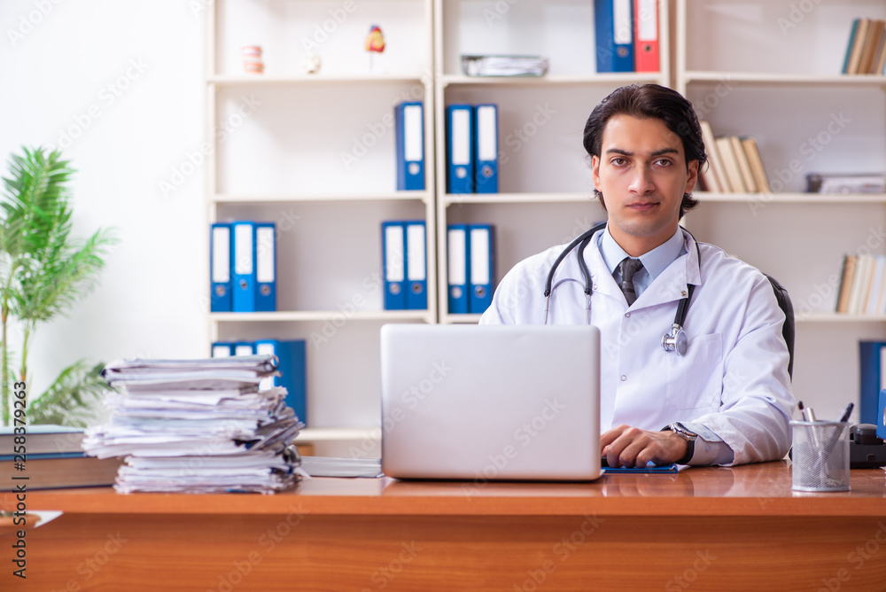 Young handsome doctor working in the clinic