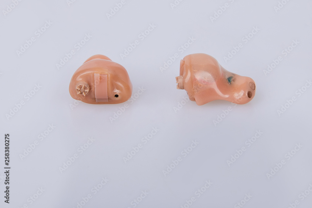 Left and right modern hearing aids on white background isolated, alternative to surgery Left and right modern hearing aids on white background isolated, alternative to surgery