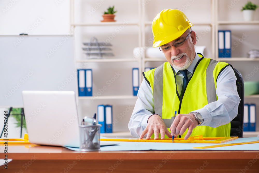 Aged construction engineer working in the office Aged construction engineer working in the office