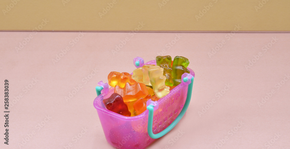 candy in glass jar on pink background