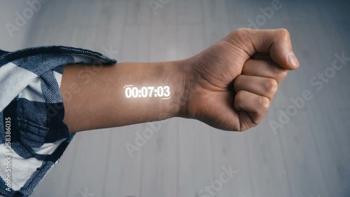 Close-up Man starting up a Hologram Futuristic Stopwatch on his hand photo