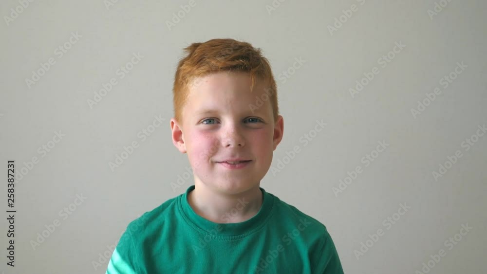 Portrait of happy red hair boy with freckles. Adorable handsome baby looking into camera with smile. Close up emotions of male child with glad expression on face. Slow motion Close up Portrait of happy red hair boy with freckles. Adorable handsome baby looking into camera with smile. Close up emotions of male child with glad expression on face. Slow motion Close up