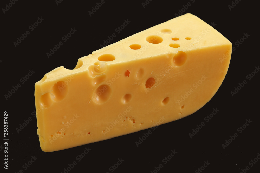 Cheese with big holes against dark background Cheese with big holes against dark background