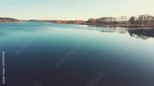 Aerial shot of big river flowing near mixed forest land