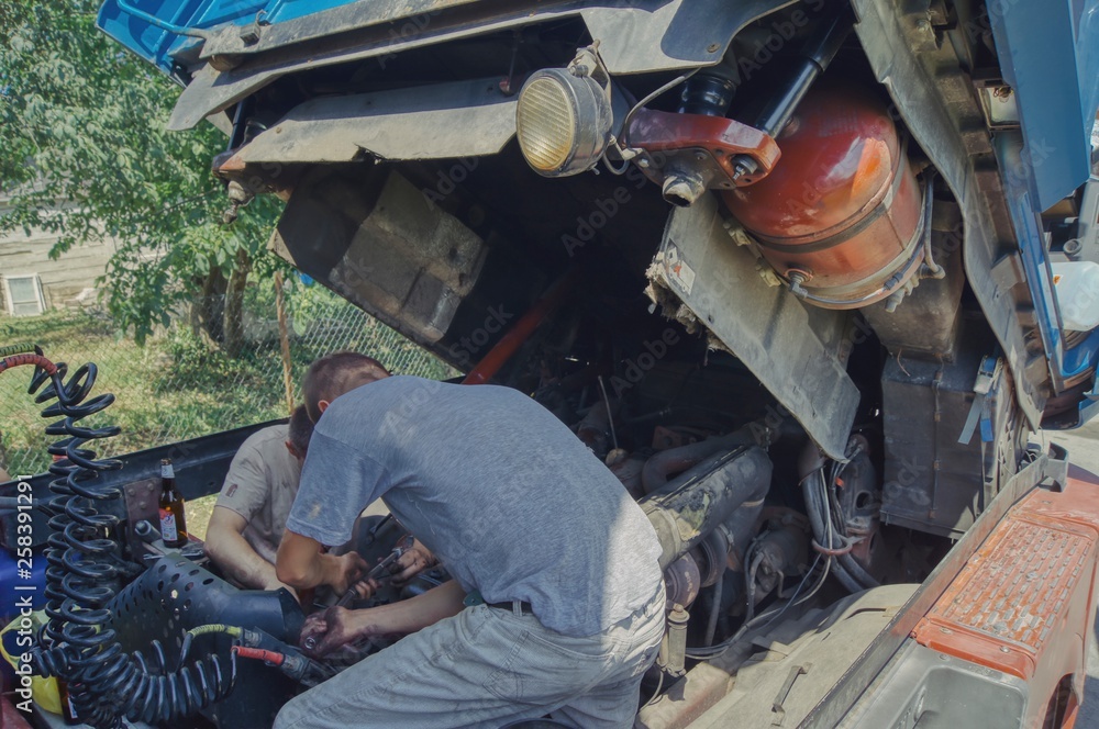 breakdown in the countryside away from the city, two men repair the truck, work hard on a hot day breakdown in the countryside away from the city, two men repair the truck, work hard on a hot day