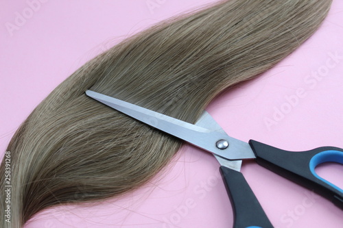Strand of hair lie with scissors to cut