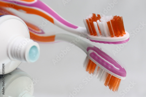 Toothbrushes and toothpaste on a mirror shelf. Oral hygiene products.