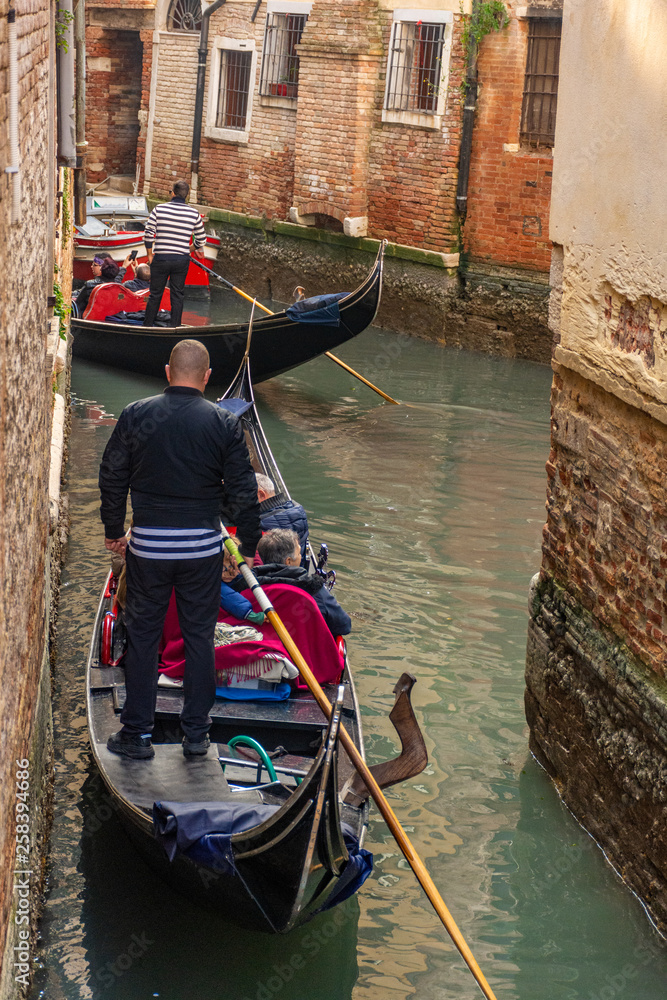 Italy, Venice, view of canals with gondolas carrying visiting tourists.