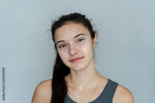 portrait of a young girl who is looking at the camera in front of her  wall background