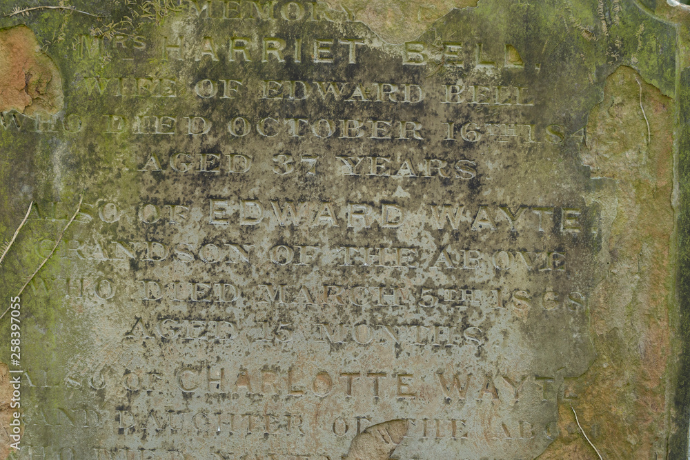 An Old Gravestone surface with text letters on it, close up