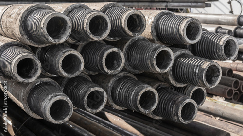 Quadro su tela Drill pipes for drilling oil and gas wells are located horizontally on the rack