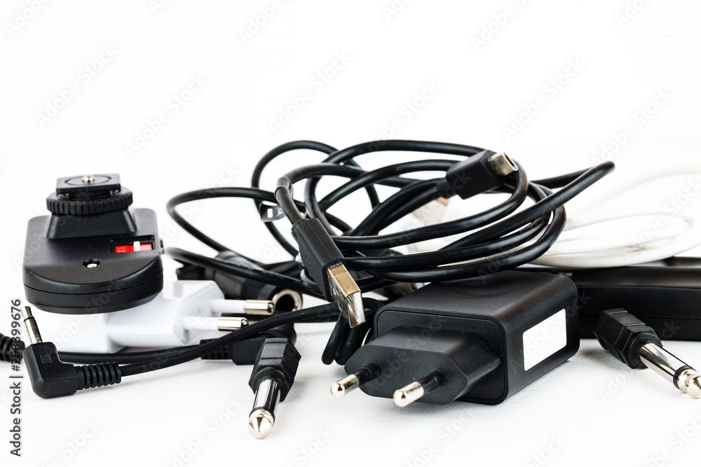 Different wires and connectors on a white background, equipment mess Different wires and connectors on a white background, equipment mess