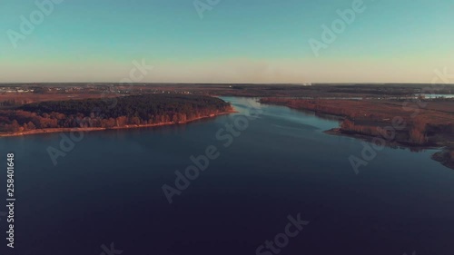 Aerial view of a big river flowing near forest