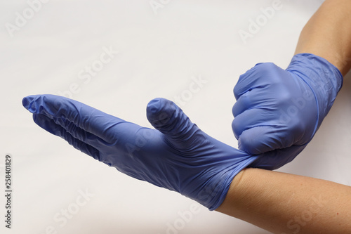 Blue gloves on hand. Syringe with a needle. Preparation for the injection of the drug.
