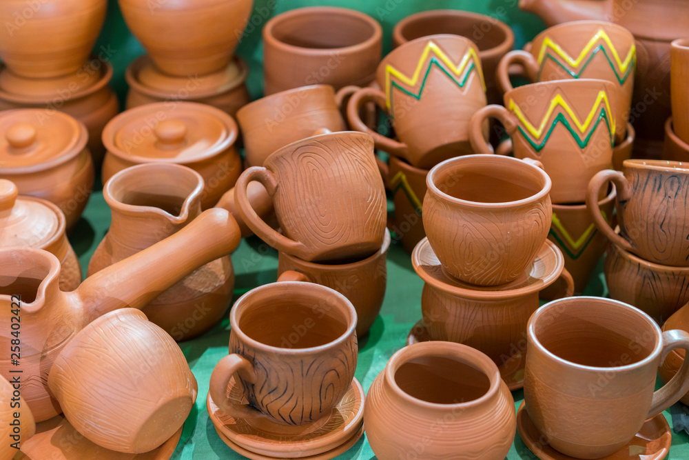 Lots of traditional ukrainian handmade clay pottery production. brown pottery. Clay plates and cups Lots of traditional ukrainian handmade clay pottery production. brown pottery. Clay plates and cups