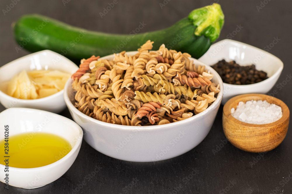 Set of ingredients. recipe step by step fusilli pasta with zucchini on grey stone Set of ingredients. recipe step by step fusilli pasta with zucchini on grey stone