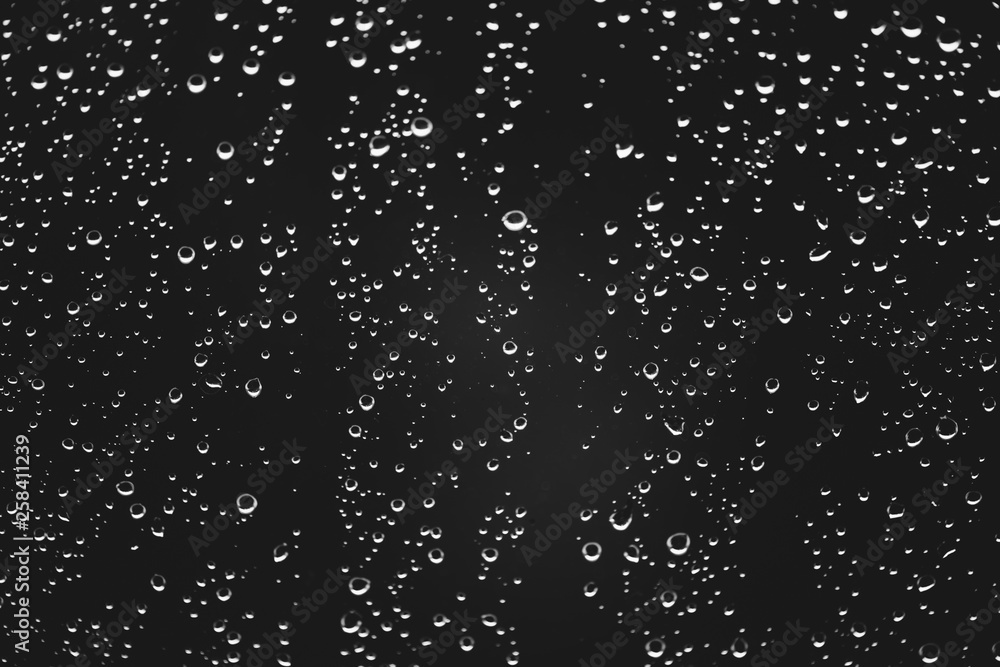 Dirty window glass with drops of rain. Atmospheric monochrome dark background with raindrops. Droplets and stains close up. Detailed transparent texture in macro with copy space. Rainy weather. Dirty window glass with drops of rain. Atmospheric monochrome dark background with raindrops. Droplets and stains close up. Detailed transparent texture in macro with copy space. Rainy weather.