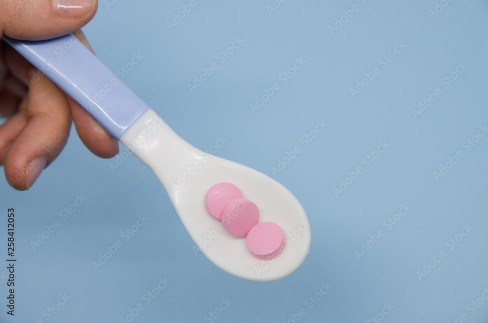 Medical pink pills in a spoon Medical pink pills in a spoon