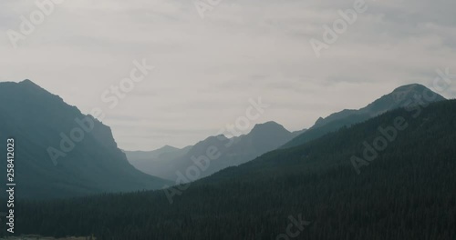 Slow aerial big sky fly above mountain valley with peaks all around, drone footage.