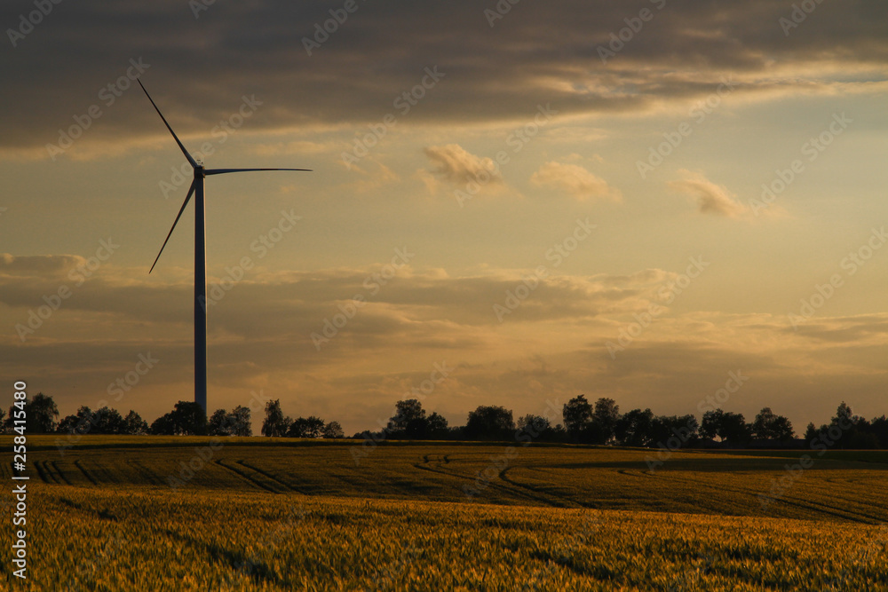 wind turbine at sunset with cloudy sky in the background wind turbine at sunset with cloudy sky in the background