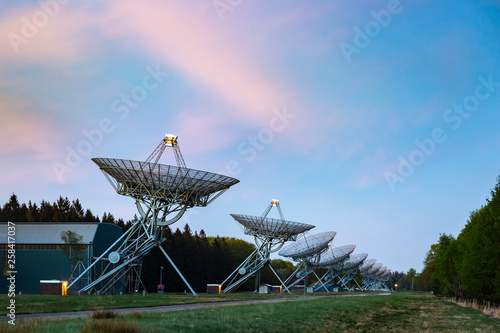 The Westerbork Synthesis Radio Telescope (WSRT) during dusk, with a light cloudy sky and stars a little visible photo