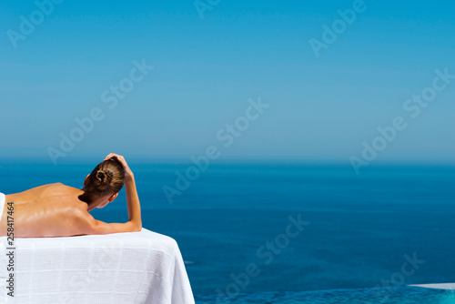 Woman on massage table facing sea