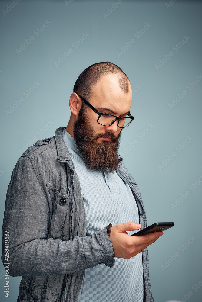 lifestyle brooding man with a beard and a telephone, background, copyspace lifestyle brooding man with a beard and a telephone, background, copyspace