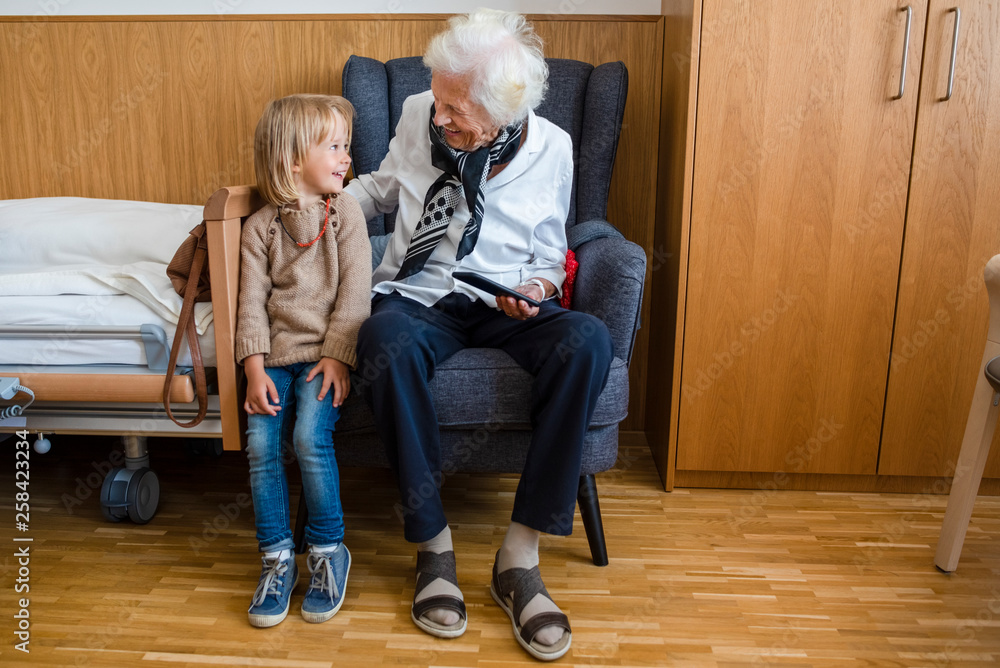 Aged woman and her great-granddaughter having fun together Aged woman and her great-granddaughter having fun together