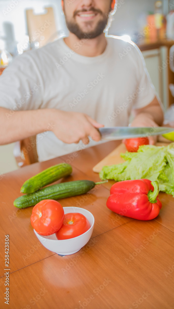 a man cooks in the kitchen he cuts vegetables a man cooks in the kitchen he cuts vegetables