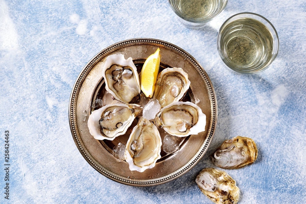 Fresh ocean oysters with slices of lemon on ice. Fresh ocean oysters with slices of lemon on ice.