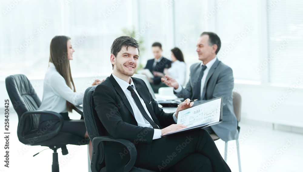 business man at office with his business team working behind business man at office with his business team working behind