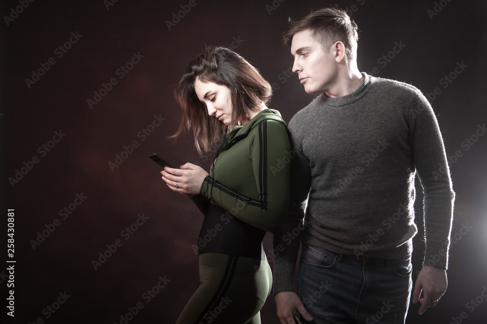 A man spies like a woman is on the phone. Social networking. The girl is typing SMS. Husband watches wife. A man spies like a woman is on the phone. Social networking. The girl is typing SMS. Husband watches wife.