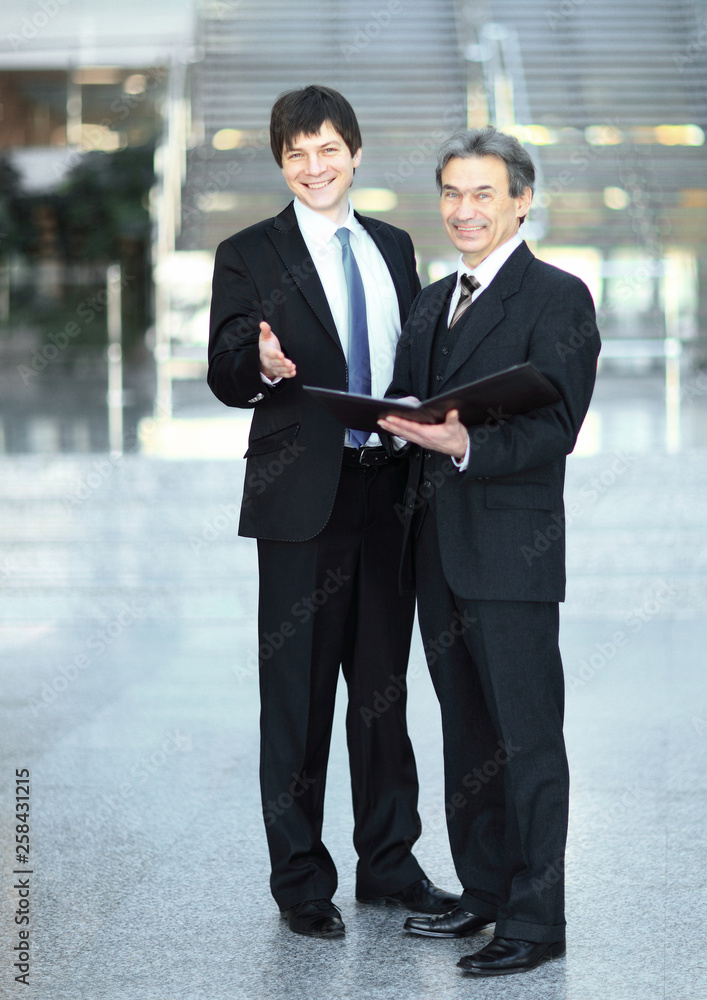 business partners with documents standing in the office. business partners with documents standing in the office.