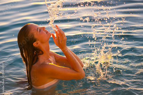 Young woman splashing her face