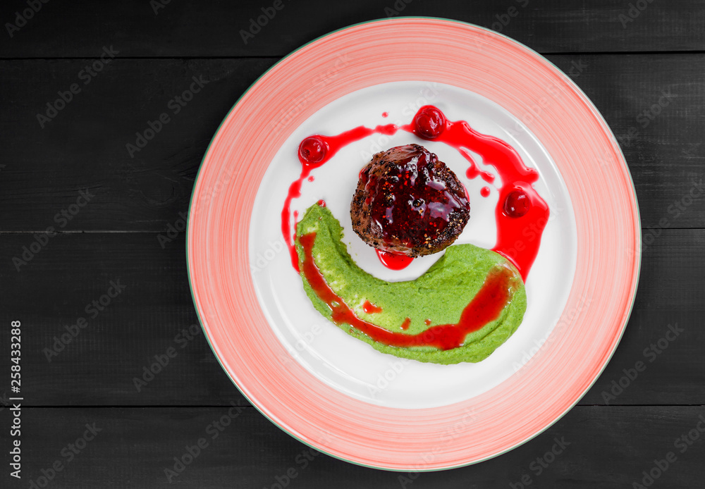 Grilled beef steak meat with berries and avocado sauce in plate. Hot Meat Dishes. Top view, flat lay Grilled beef steak meat with berries and avocado sauce in plate. Hot Meat Dishes. Top view, flat lay
