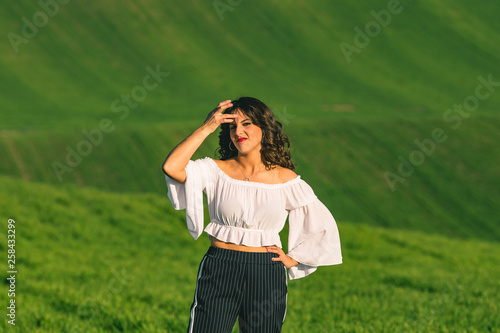 Woman on nature over summer field background. Poses on nature