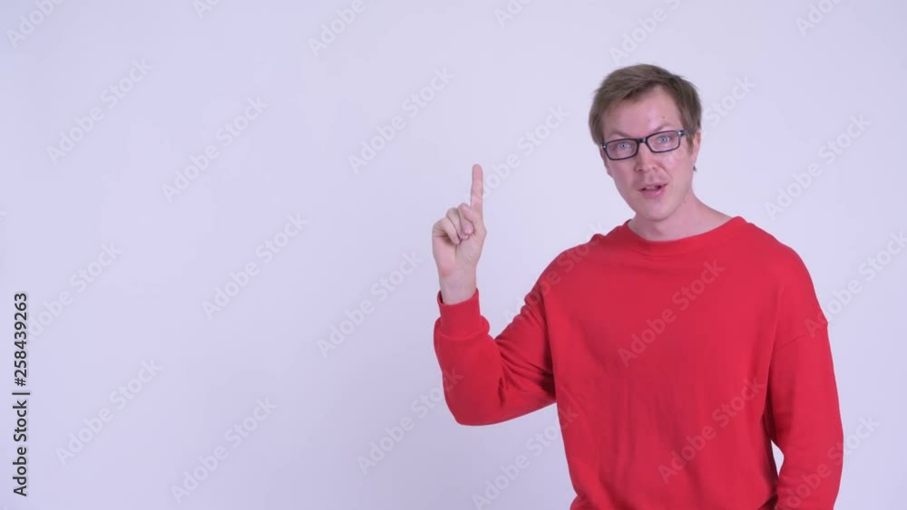 Happy young handsome man thinking and pointing up Happy young handsome man thinking and pointing up