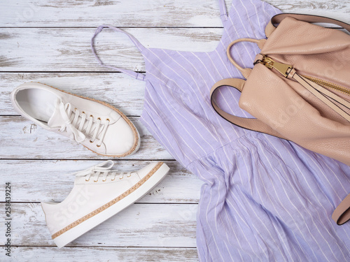 Womens clothing, shoes, accessories (lavender dress, white leather sneakers, beige backpack). Fashion outfit, spring summer collection. Shopping concept. Flat lay, view from above