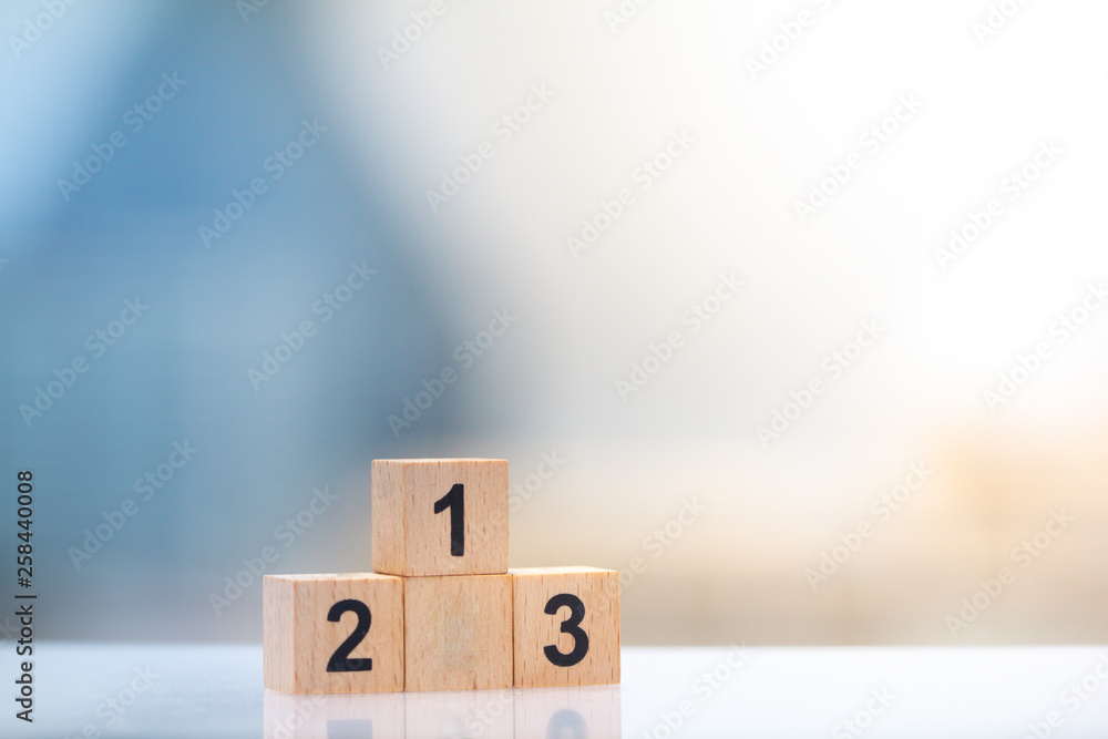 Wooden block winner podium first, second, and third place on cityscape ...