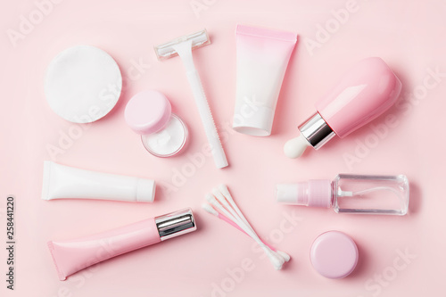 Face care products (tonic or lotion, serum, cream, micellar water, cotton pads and sticks, shaver) on powder background. Freshness and body care. Skin care and anti-age care. Female everyday cosmetics
