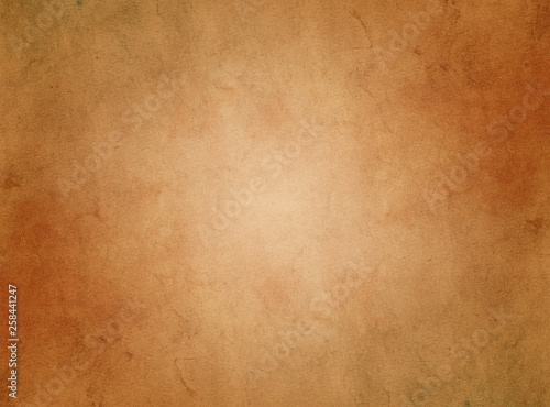 An elegant, brown, tan, grunge parchment texture background with glowing center and copy space for text. 