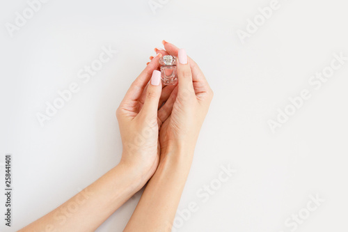 small bottle of perfume in female hands. Little aroma bottle in woman's hands/ Arome therapy