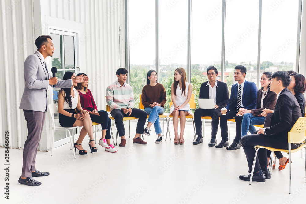 Businessman standing in front of group of people in consulting meeting conference seminar at hall or seminar room.presentation and coaching concept Businessman standing in front of group of people in consulting meeting conference seminar at hall or seminar room.presentation and coaching concept